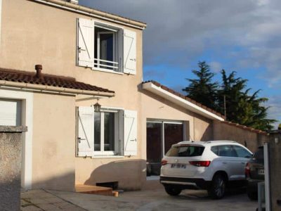 Façade d'une maison avec places de parking pour deux voitures